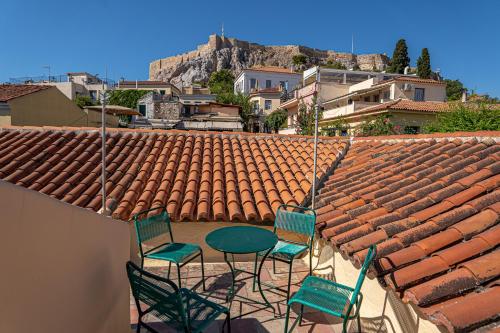 three chairs and a table on top of a roof at A Painter's House in Plaka in Athens