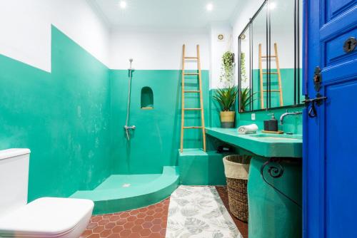 a blue bathroom with a toilet and a sink at El Patio Andaluz in Vélez-Málaga