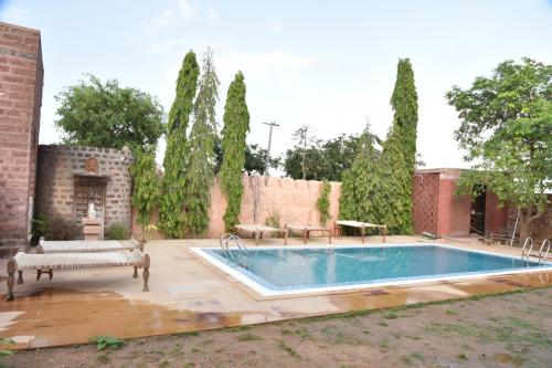 - une piscine dans une cour arborée dans l'établissement Osian The Desert Boutique Hotel, à Khāra