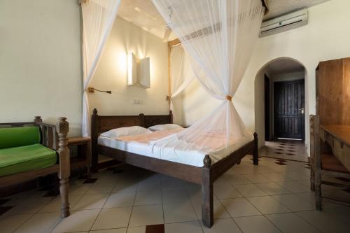 a bedroom with a bed with a mosquito net at Severin Sea Lodge in Mombasa