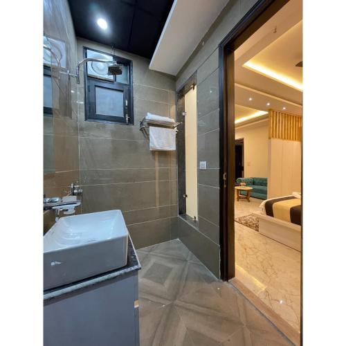 a bathroom with a sink and a shower at Maps Inn in Ghaziabad