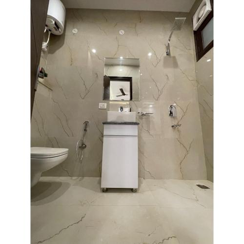 a bathroom with a toilet and a sink at Maps Inn in Ghaziabad