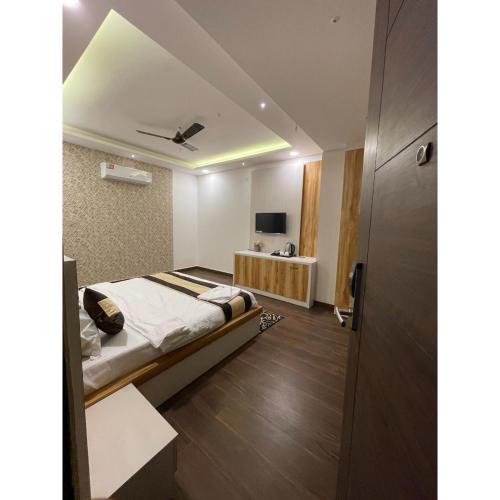 a bedroom with a bed and a television in it at Maps Inn in Ghaziabad