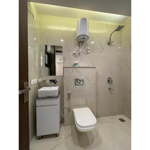 a bathroom with a toilet and a sink and a shower at Maps Inn in Ghaziabad