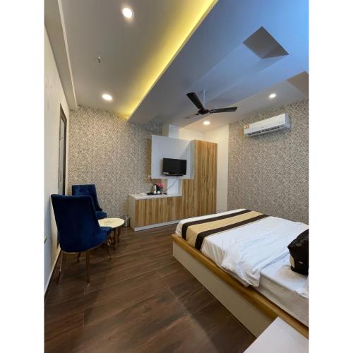 a bedroom with a bed and a desk and a tv at Maps Inn in Ghaziabad