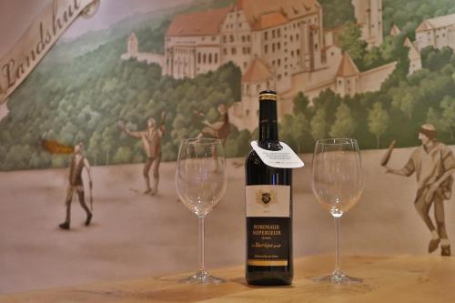 una bottiglia di vino e due bicchieri di vino su un tavolo di Vils-Residenz a Vilsbiburg