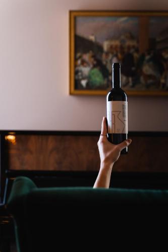 a person holding up a bottle of wine at Conca Bella Boutique Hotel & Wine Experience in Vacallo