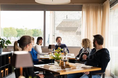 a group of people sitting around a table in a restaurant at Conca Bella Boutique Hotel & Wine Experience in Vacallo