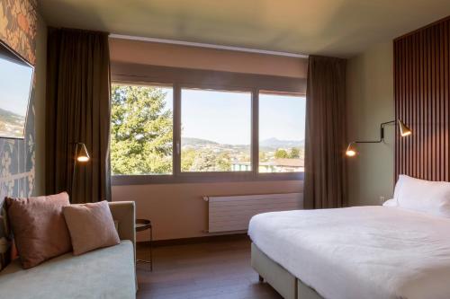 a hotel room with a large bed and a window at Conca Bella Boutique Hotel & Wine Experience in Vacallo