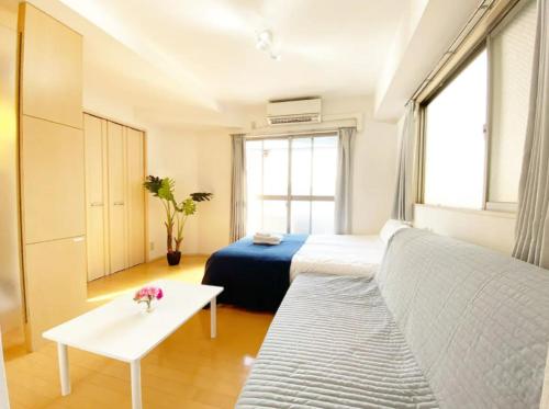 Cette chambre comprend un lit, un canapé et une table. dans l'établissement Tsunoya, à Tokyo