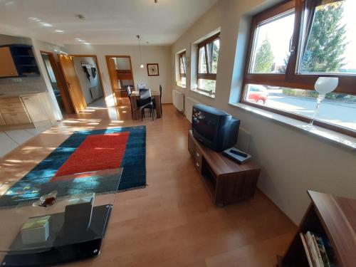 a living room with a television and a living room with a table at Ferienwohnung Pfaffenweiler Villingen Schwenningen in Villingen-Schwenningen