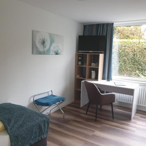 a small room with a desk and a bed and a window at Kurparkhotel-Gemünd in Gemünd