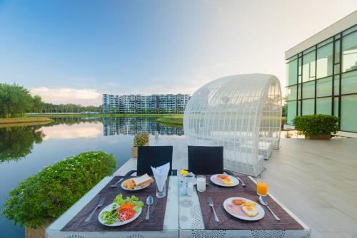 a table with food on it next to a body of water at Wyndham Royal Lee Phuket in Nai Yang Beach