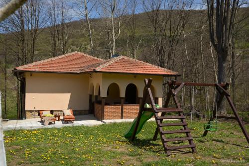 un parco giochi di fronte a una casa con un edificio di Lek za dušu a Despotovac
