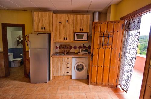 a kitchen with a refrigerator and a washing machine at Alojamiento Rural Sierra de Jerez in Jerez del Marquesado