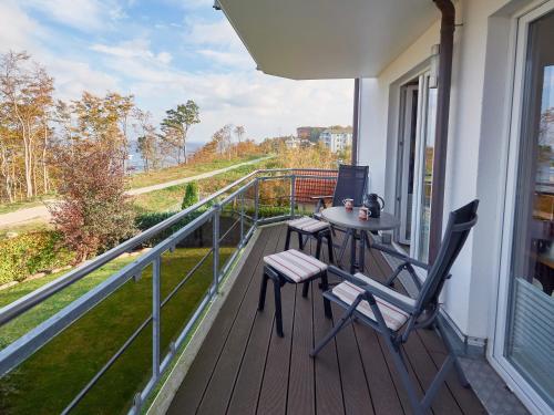 un porche con 2 sillas y una mesa en el balcón en Residenz Falkenberg - Apt. 06, en Ostseebad Sellin