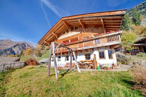 a house with a wooden roof on a hill at Unterstuanerhof Plattnerblick in Stulles
