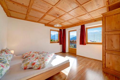 um quarto com uma cama e duas janelas em Unterstuanerhof Plattnerblick em Stulles