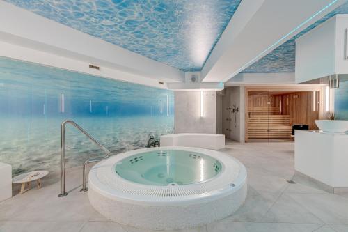 a bathroom with a bath tub with a ocean themed ceiling at Apartamenty Rondo in Świnoujście