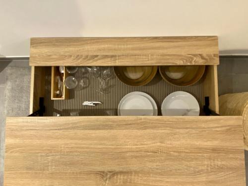 drewniana szafka z talerzami i naczyniami w obiekcie Central and Convenient Studio in Monaco w Monte Carlo