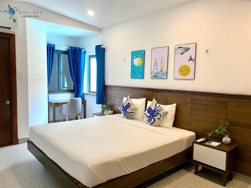 Schlafzimmer mit einem großen Bett und blauen Vorhängen in der Unterkunft Nicobar Con Dao Hotel in Con Dao