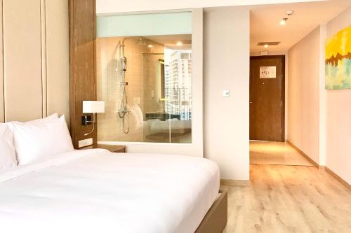 a bedroom with a white bed and a shower at Panorama Nha Trang Inn in Nha Trang