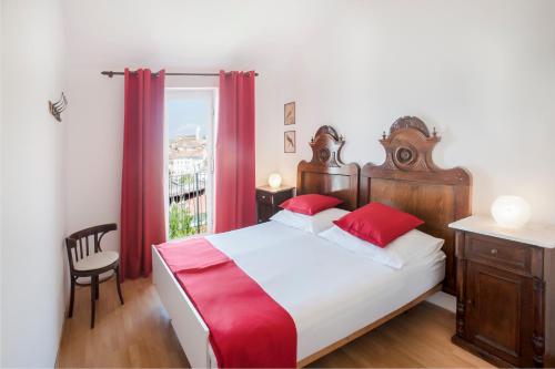 a bedroom with a bed and a window with red curtains at The Best View House in Piran