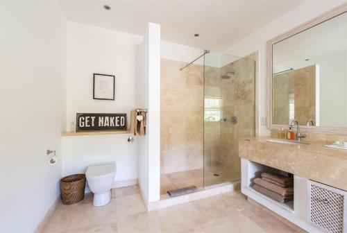 a bathroom with a shower and a toilet and a sink at Shimmers, stunning, stylish West Coast Villa in Saint Peter