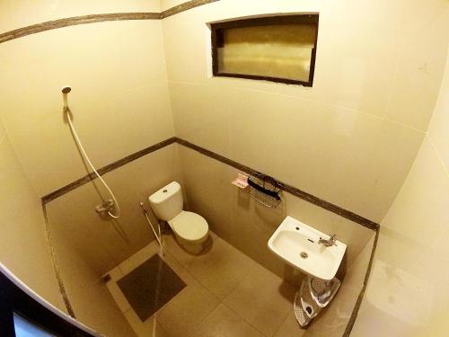 een kleine badkamer met een toilet en een wastafel bij Godean Living Homestay Jogja Family only in Ngabean