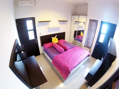 een slaapkamer met een groot roze bed met roze kussens bij Godean Living Homestay Jogja Family only in Ngabean