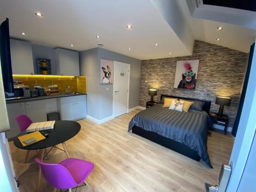 a bedroom with a king sized bed and a kitchen at Modern Luxury 1 bed apartment with parking near Stansted Airport in Stansted Mountfitchet