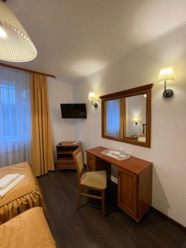 a hotel room with a desk and a mirror at Gusarskiy Hotel and Apartment in Kyiv