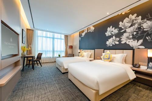 広州市にあるGHIC The Mulian Hotel of Bio-island Guangzhouのベッド2台とテレビがあるホテルの部屋