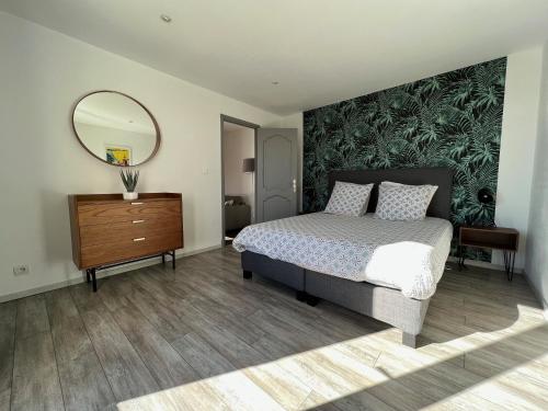 - une chambre avec un lit, un miroir et une commode dans l'établissement Villa Coris, à Draguignan