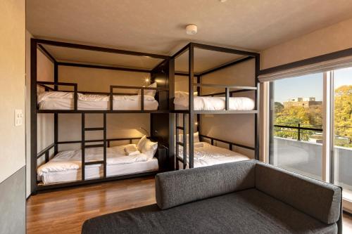 two bunk beds in a room with a couch at Hotel Ten to Ten in Sapporo