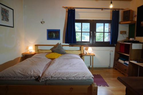 a bedroom with a bed with two lamps and a window at Wohnstudio in umgebauter Scheune in Altlassing