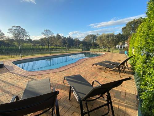 a patio with two chairs and a swimming pool at McCaffrey's Estate in Pokolbin
