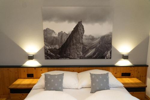 a bedroom with a painting above a bed with pillows at LUSE Living in Maurach