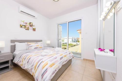 a bedroom with a bed and a large window at Villa Elaine in Protaras