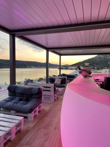 eine Terrasse mit Sofas und Tischen und einer violetten Decke in der Unterkunft Sky Beach Aparthotel in Marina