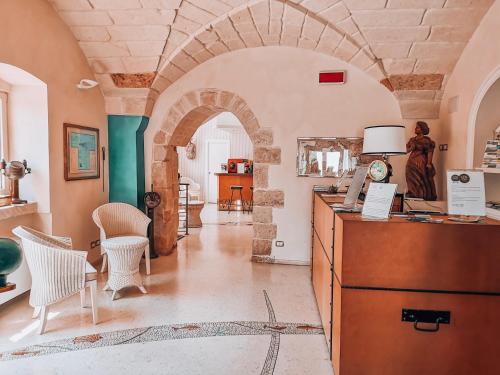 um quarto com um arco com uma secretária e cadeiras em Corte Di Nettuno - CDSHotels em Otranto