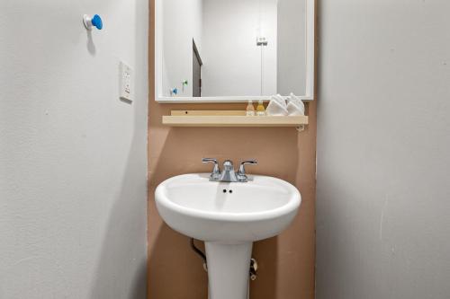 a bathroom with a white sink and a mirror at Rincon Plaza Hotel in Rincon