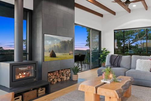 a living room with a fireplace and a couch at The Ridge at Maleny 3 Bedroom Executive Residence in Maleny