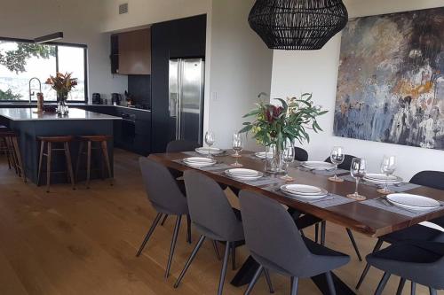a dining room table with chairs and a kitchen at The Ridge at Maleny 3 Bedroom Executive Residence in Maleny
