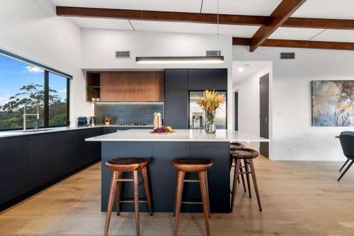 a kitchen with a large island with bar stools at The Ridge at Maleny 3 Bedroom Executive Residence in Maleny