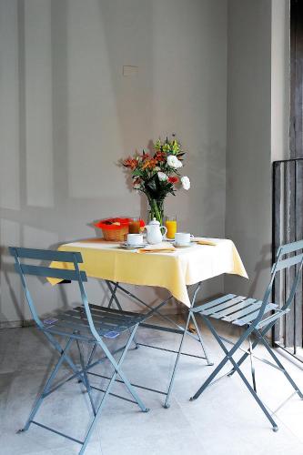 a yellow table with a vase of flowers on it at Il Convento Case Vacanze in Rapallo