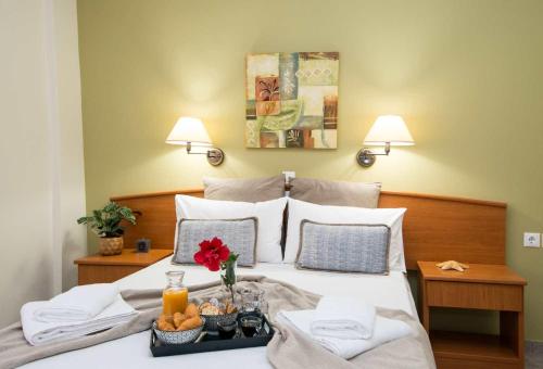 a bedroom with a bed with a tray of food on it at Spira Studios & Apartments in the Heart of Laganas in Laganas