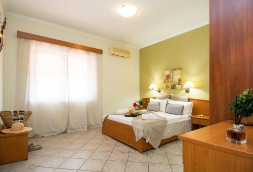 a hotel room with a bed and a window at Spira Studios & Apartments in the Heart of Laganas in Laganas