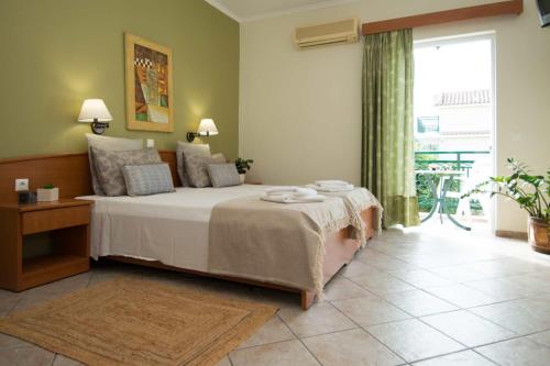 a bedroom with a bed and a large window at Spira Studios & Apartments in the Heart of Laganas in Laganas