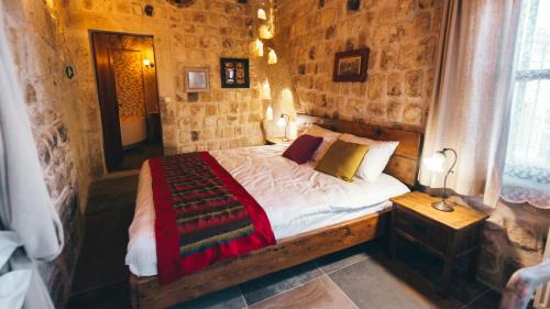 a bedroom with a bed in a stone wall at Cappadocia Old Houses in Nevsehir